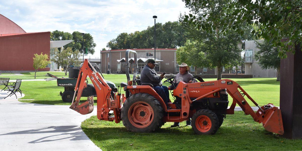 Adams State Facilities services working on tractor